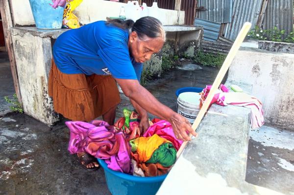 Toiling away: (Left) Susila washing her patrons’ laundry by hand at the dhoby house in Silibin. Elangovathi iro<em></em>ning her customers’ laundry. — Ro<em></em>nNIE CHIN/The Star