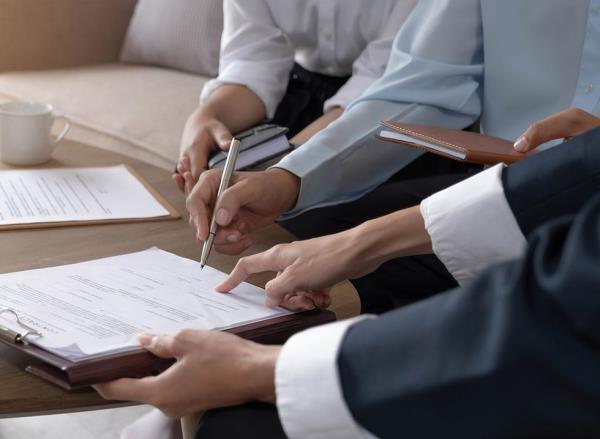 A realtor and client sign closing paperwork