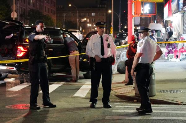 Three NYPD officers at the cordo<em></em>ned off crime scene discuss the shooting.