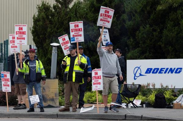 Boeing factory workers gather on a picket line during the first day of a strike near the entrance of a production facility in Renton, Wash.