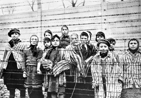 Children behind barbed wire at Auschwitz at the end of the Second World War in 1945.