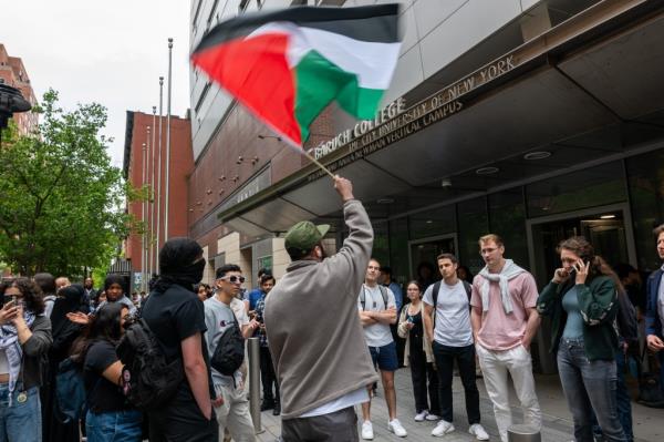 A protester waving a Palestinian flag outside Baruch College on May 9, 2024.