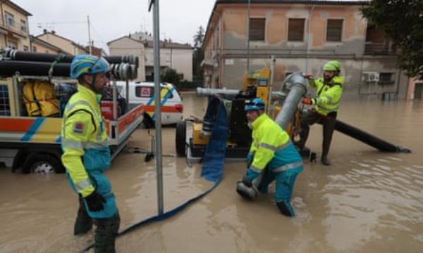 Emergency workers attempt to pump water from flooded streets in Faenza.