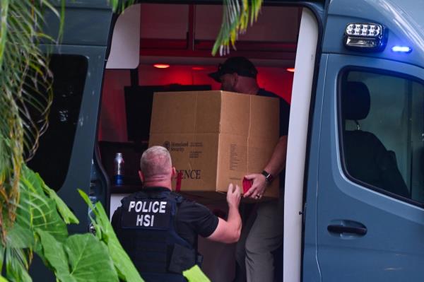 Homeland Security Investigation agents loading a box into a car at the entrance of Sean 'Diddy' Combs's home on Star Island, Miami Beach