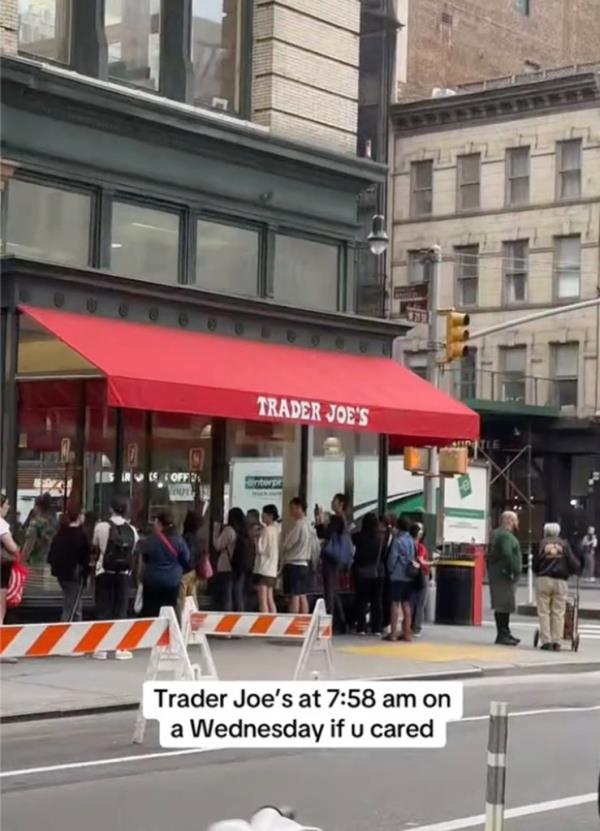 A group of people standing in line in front of a Trader Joe's store to buy popular $2.99 tote bags