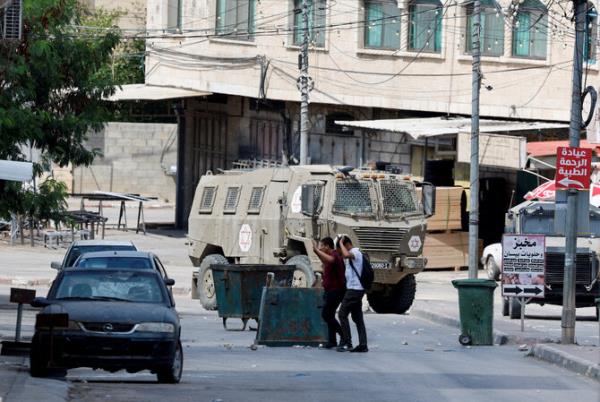 Palestinians raise their hands as they walk past Israeli forces during an Israeli raid in Qabatiya near Jenin, in Israeli-occupied West Bank, September 19, 2024. (Reuters)