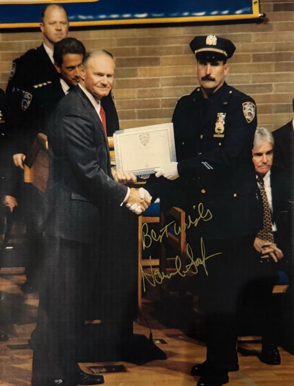 Former NYPD Commissio<em></em>ner Howard Safir hands an award to Robert Fawcett.