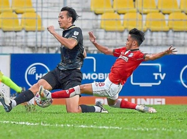 Flying high: Hadi Fayyadh Abdul Razak of Police (in black) going for a shot while Sabah’s Farhan Roslan tries to stop him. - Bernama