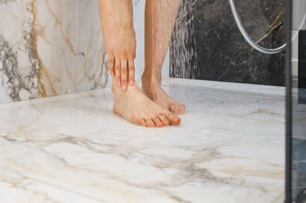 man washing his feet in the shower