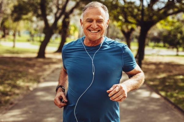 Portrait of a senior man in fitness wear running in a park