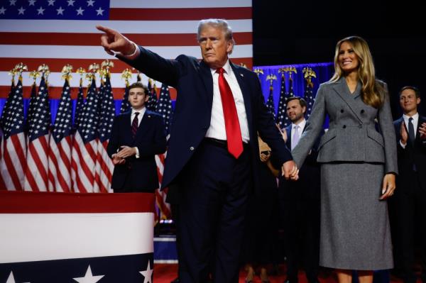 Trump points to supporters with former first lady Melania Trump during an election night event at the Palm Beach Co<em></em>nvention Center on November 06, 2024 in Florida. 