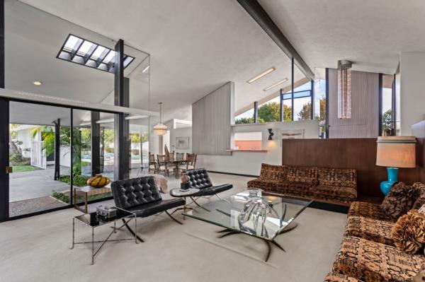 The Reicher family has preserved the property, maintaining its original mid-century details such as a Palos Verdes stone-flanked fireplace, built-in sofa, Formica kitchen countertops, and jalousie windows.