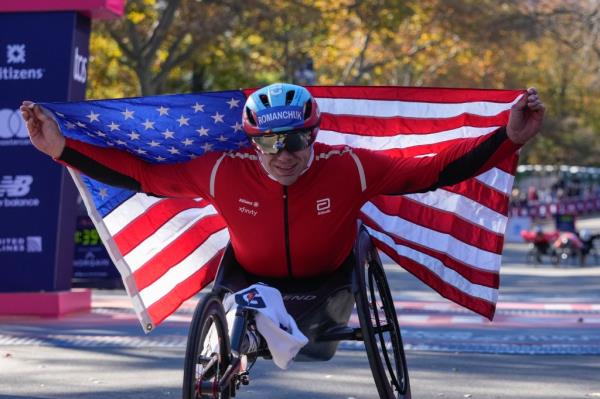 Daniel Romanchuk poses for photos after winning the men's wheelchair division of the New York City Marathon, Sunday, Nov. 3, 2024, in New York. 