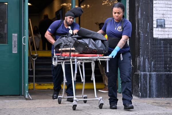 Workers carrying out the body of a 14-year-old subway surfer who was struck in Brooklyn last year.