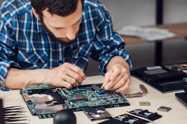 a man works on an electro<em></em>nic board