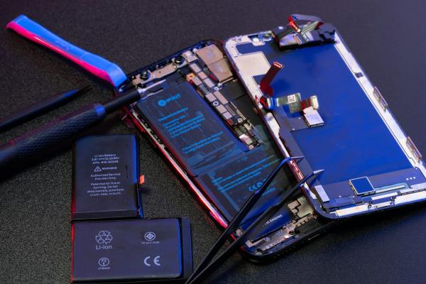 repair tools lie next to a disassembled mobile phone