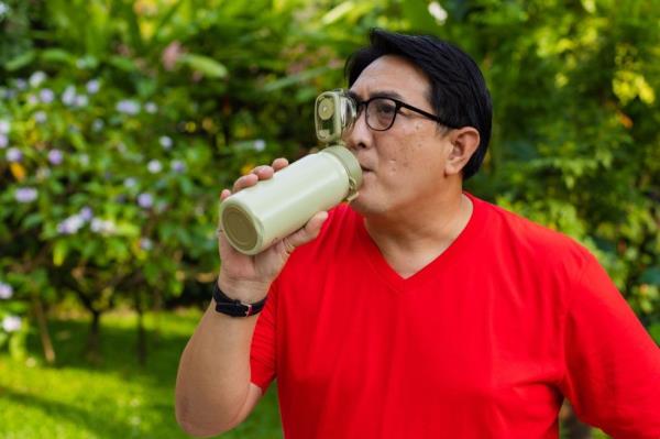 Man drinks water from water bottle.