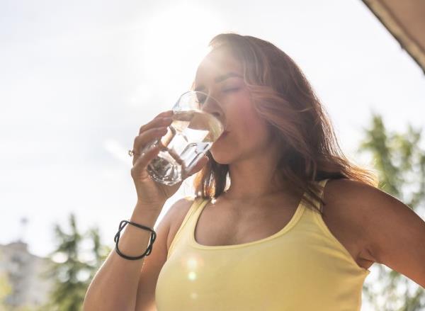 Woman drinking water in the sunshine