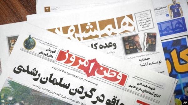 The front pages of the Aug. 13 edition of the Iranian newspapers, Vatan-e Emrooz, front, with the headline 'Knife in the neck of Salman Rushdie,' and Hamshahri, rear, with the headline: 'Attack on writer of Satanic Verses,' are pictured in Tehran, Aug. 13, 2022.