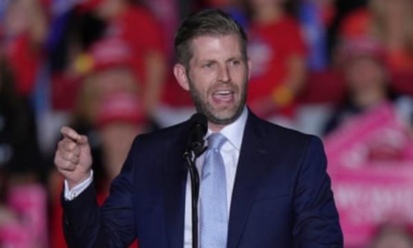 Eric Trump gestures while speaking in front of a crowd