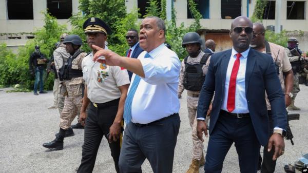 FILE - Haitian interim Prime Minister Garry Co<em></em>nille points as he walks with Police Chief Normil Rameau, left, in Port-au-Prince, Haiti, July 9, 2024. 