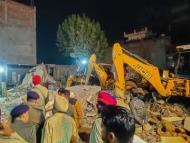  Police perso<em></em>nnel and others during a rescue operation after a multistorey building collapsed at Sohana village. (PTI)