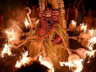 The Theyyam performer, o<em></em>nce a mere mortal, takes on the mantle of the divine, offering blessings and wisdom to those who come to witness this sacred ritual. (Image: Idrees MOHAMMED/AFP)