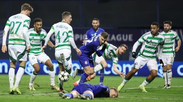 Maxime Bernauer of Dinamo Zagreb lies on the turf as Celtic scramble clear