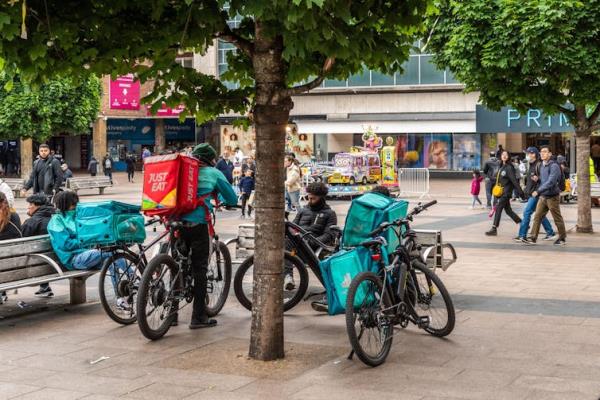 Food delivery riders hanging around in a shopping precinct