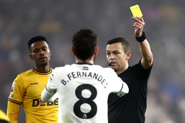 Referee Tony Harrington showing a yellow card to Manchester United’s Bruno Fernandes during the match against Wolverhampton Wanderers.  — AFP