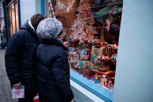 Passers-by examine Christmas items displayed in the window of 43 Camden Passage, owned by Bob Borzello, in Lo<em></em>ndon on December 20, 2024. — AFP pic