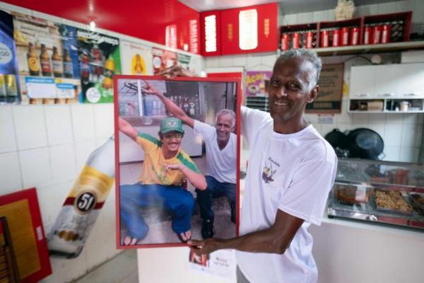 Ro<em></em>naldo Teixeira, owner of Bar do Lacador, shows a photo of him with singer Bruno Mars at the bar in Belo Horizonte, Brazil, on December 11, 2024. — AFP pic