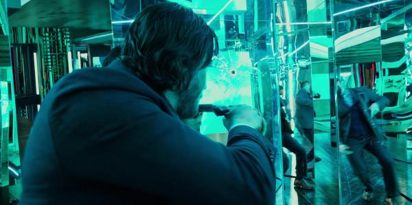 Keanu Reeves points his gun as John Wick in a hall of mirrors in John Wick 2