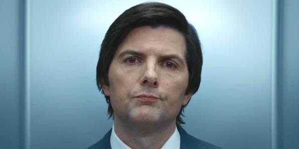 Adam Scott, as Mark, wearing a professio<em></em>nal suit, standing in the elevator with a tired yet pensive look on his face  | Severance on Apple TV+