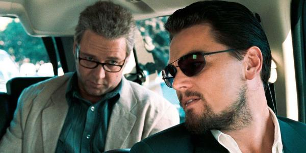 Leo<em></em>nardo DiCaprio leaning back to talk to Russell Crowe behind him in a car in Body of Lies