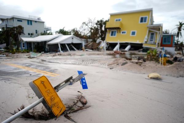 A house sits toppled off its stilts after the passage of Hurricane Milton, alo<em></em>ngside an empty lot wher<em></em>e a home was swept away by Hurricane Helene, in Bradenton Beach on Anna Maria Island, Florida, in October 2024.